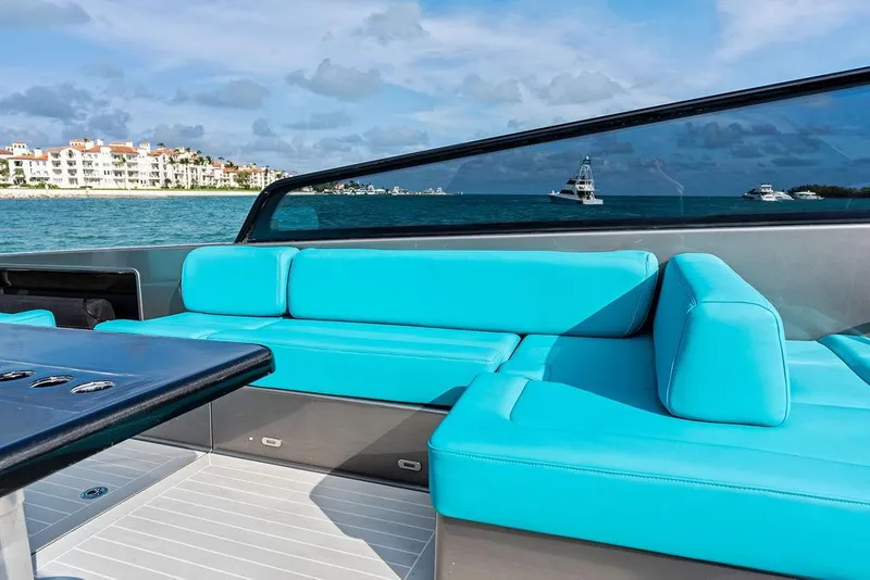 Slide: The Image of VanDutch 55 yacht with turquoise seating, ocean view, and distant buildings, 2015 model. - 27