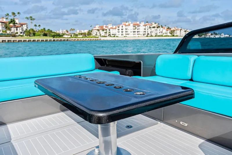 Slide: The Image of Luxurious 2015 VanDutch 55 yacht interior with turquoise seating and sleek table, coastal backdrop. - 29