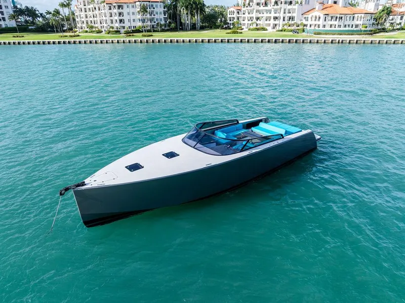 Slide: The Image of VanDutch 55 yacht, 2015 model, floating on turquoise water near luxury waterfront buildings. - 3