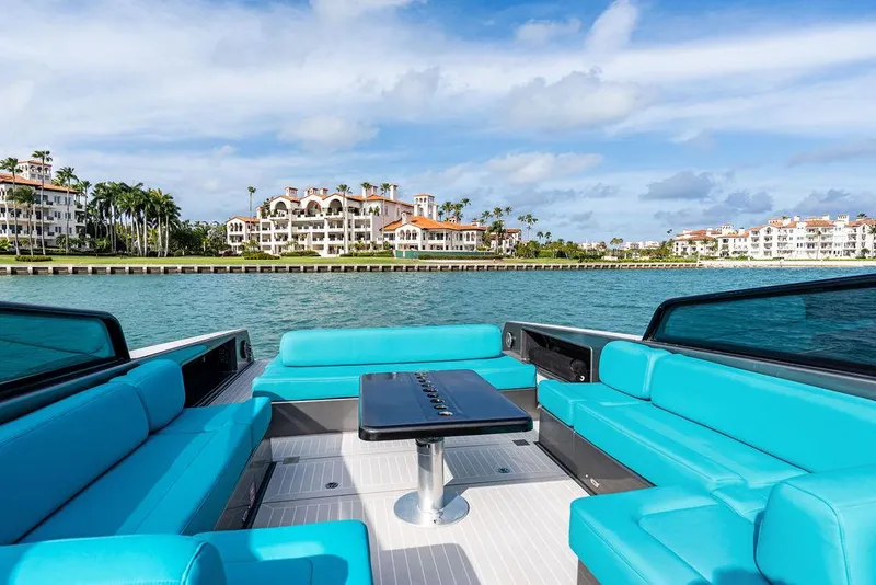 Slide: The Image of Luxurious 2015 VanDutch 55 yacht with turquoise seating, cruising near waterfront mansions. - 31