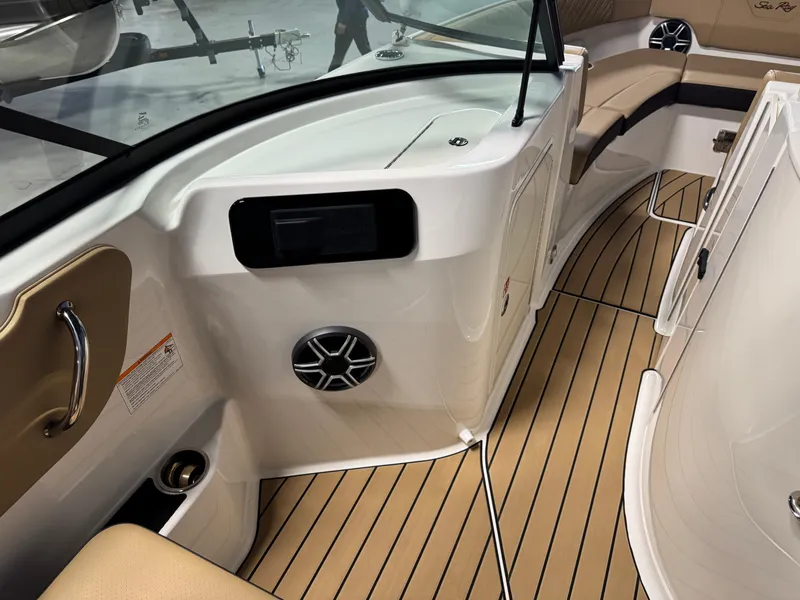 Slide: The Image of 2026 Sea Ray SDX 250 Surf boat interior with tan seating and wood-style flooring. - 14