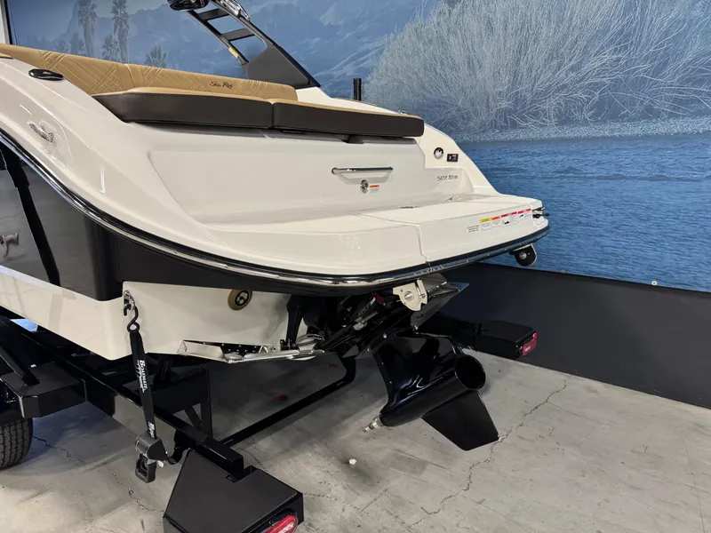 Slide: The Image of 2026 Sea Ray SDX 250 Surf boat rear view on trailer indoors. - 4