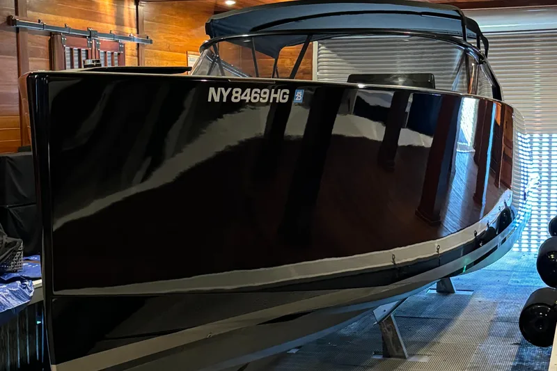 Slide: The Image of 2019 VanDutch 40 boat in a garage, sleek black exterior, registration NY8469HG. - 3