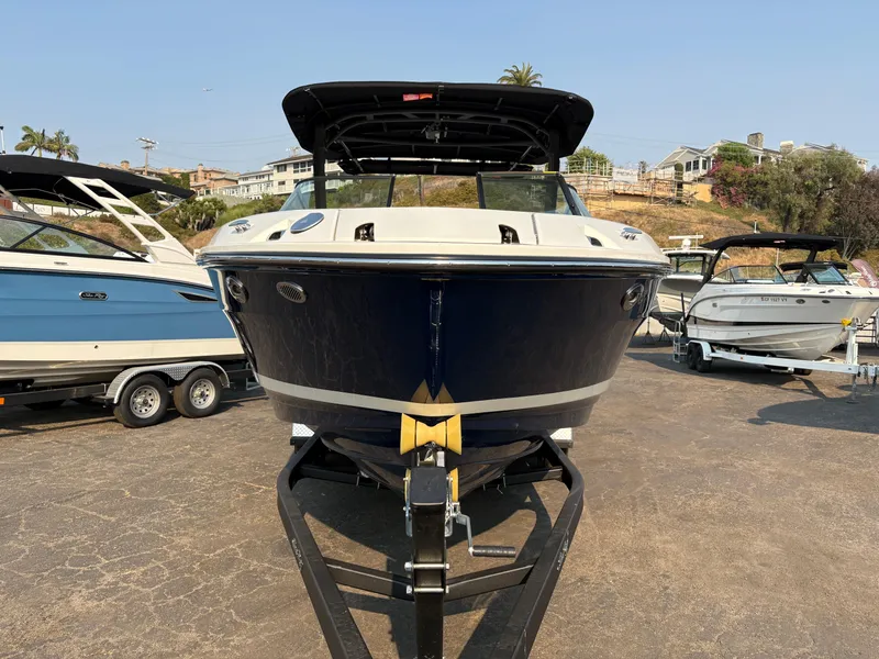 Slide: The Image of 2026 Sea Ray SLX 260 boat on trailer, parked outdoors in a marina setting. - 1