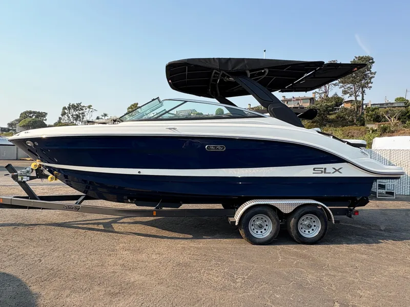 Slide: The Image of 2026 Sea Ray SLX 260 boat on trailer, featuring sleek design and black canopy. - 2