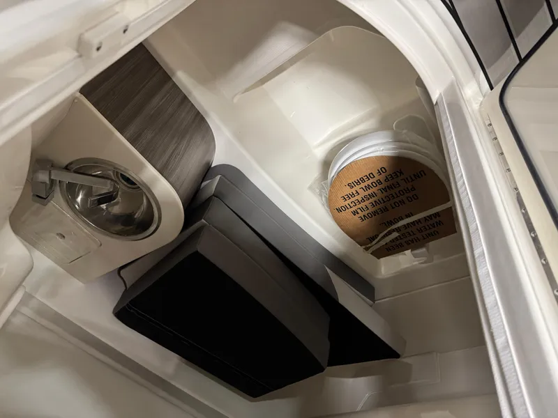 Slide: The Image of 2026 Sea Ray SDX 270 interior storage compartment with sink and protective cover. - 17