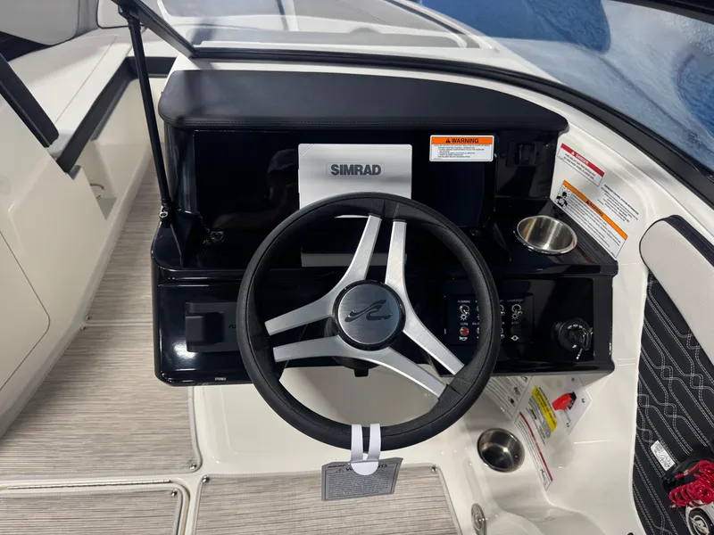 Slide: The Image of 2026 Sea Ray SPX 210 boat dashboard with steering wheel and Simrad display. - 14