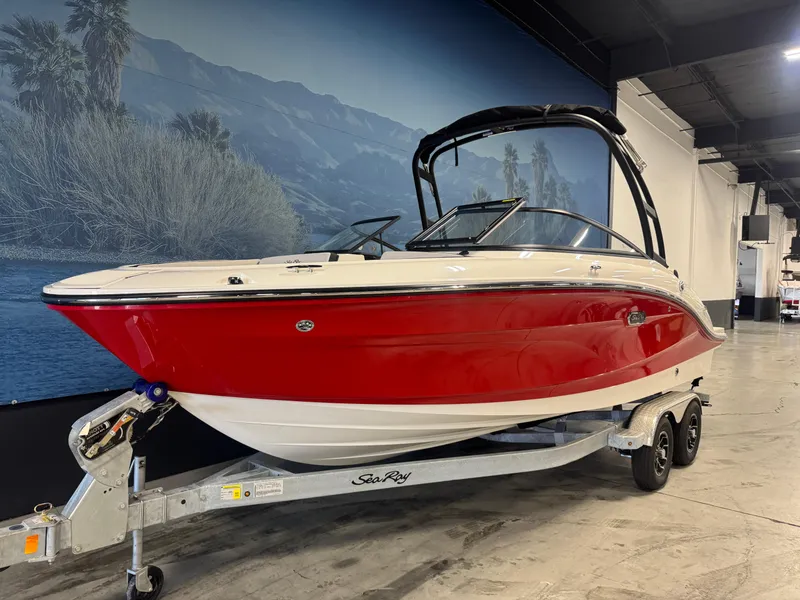 Slide: The Image of 2026 Sea Ray SPX 210 boat with red hull on trailer in showroom. - 3