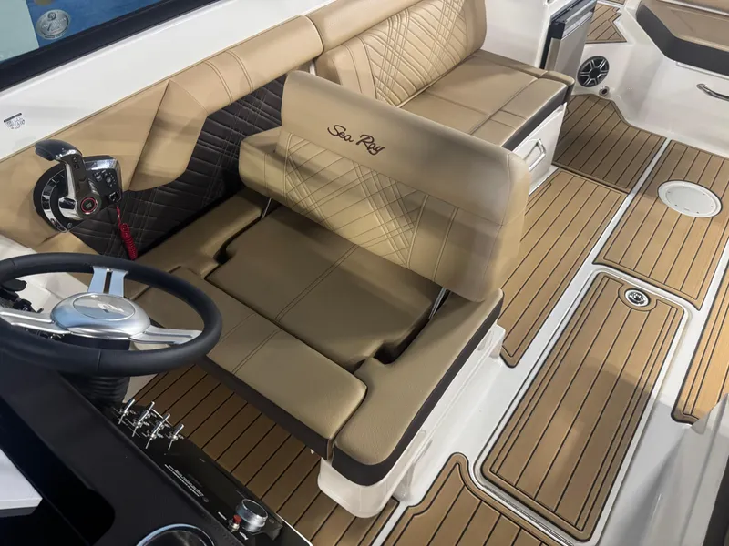 Slide: The Image of 2026 Sea Ray SDX 290 boat interior with tan seating and modern steering wheel. - 13