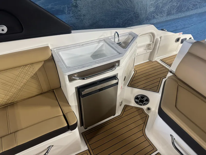 Slide: The Image of 2026 Sea Ray SDX 290 boat interior with tan seating, sink, and mini fridge. - 8