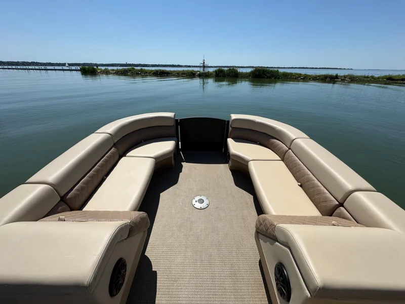 Slide: The Image of 2023 Massimo Marine P24 boat interior with beige seating on calm water. - 10