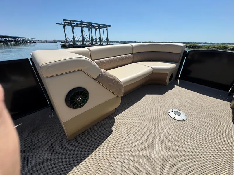 Slide: The Image of Luxurious seating on 2023 Massimo Marine P24 boat, featuring beige upholstery and scenic water view. - 11