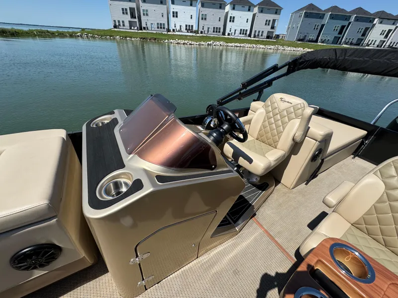 Slide: The Image of 2023 Massimo Marine P24 boat interior with luxurious seating and modern dashboard, near waterfront homes. - 15