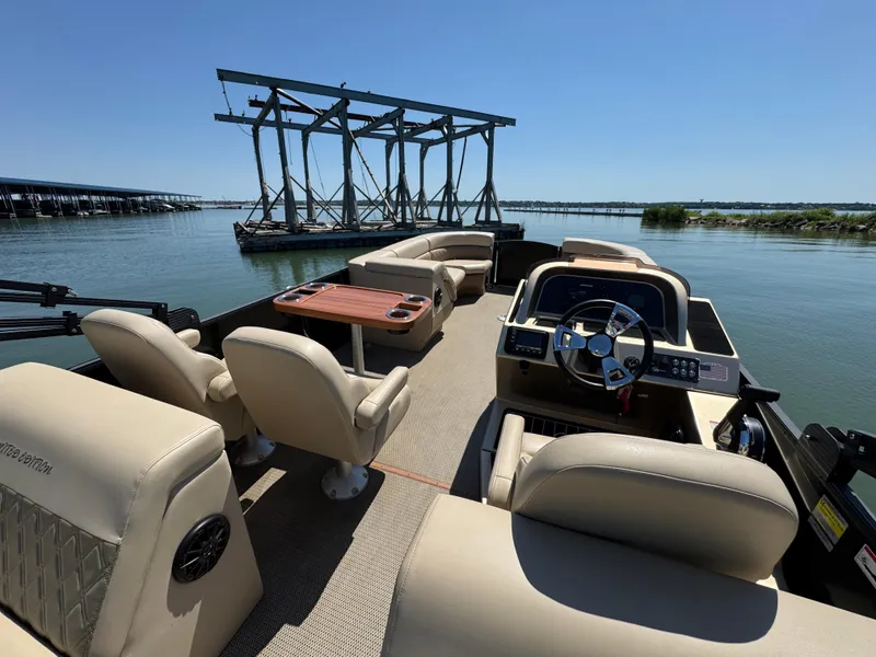 Slide: The Image of Luxurious 2023 Massimo Marine P24 pontoon boat interior with plush seating and steering console. - 28