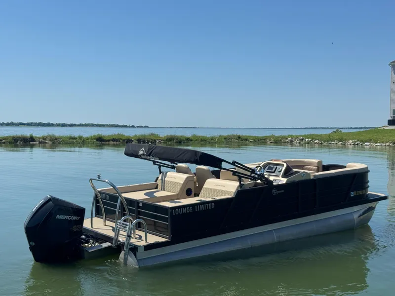 Slide: The Image of 2023 Massimo Marine P24 pontoon boat on calm water, featuring a sleek design and comfortable seating. - 4