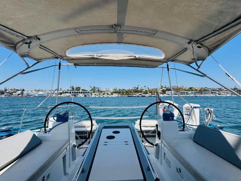 Slide: The Image of Beneteau Oceanis 41.1 sailboat cockpit view, 2020 model, overlooking serene waters and distant shoreline. - 21