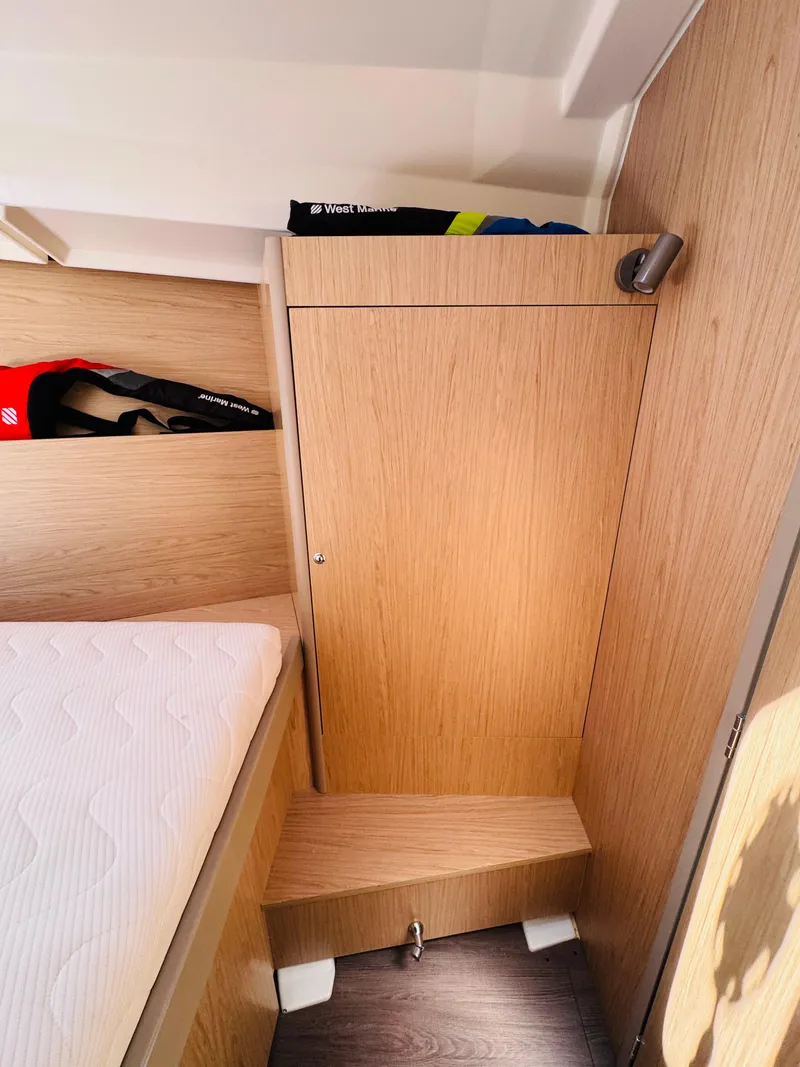 Slide: The Image of Interior cabin of 2020 Beneteau Oceanis 41.1 yacht, featuring wooden cabinetry and a cozy bed. - 36