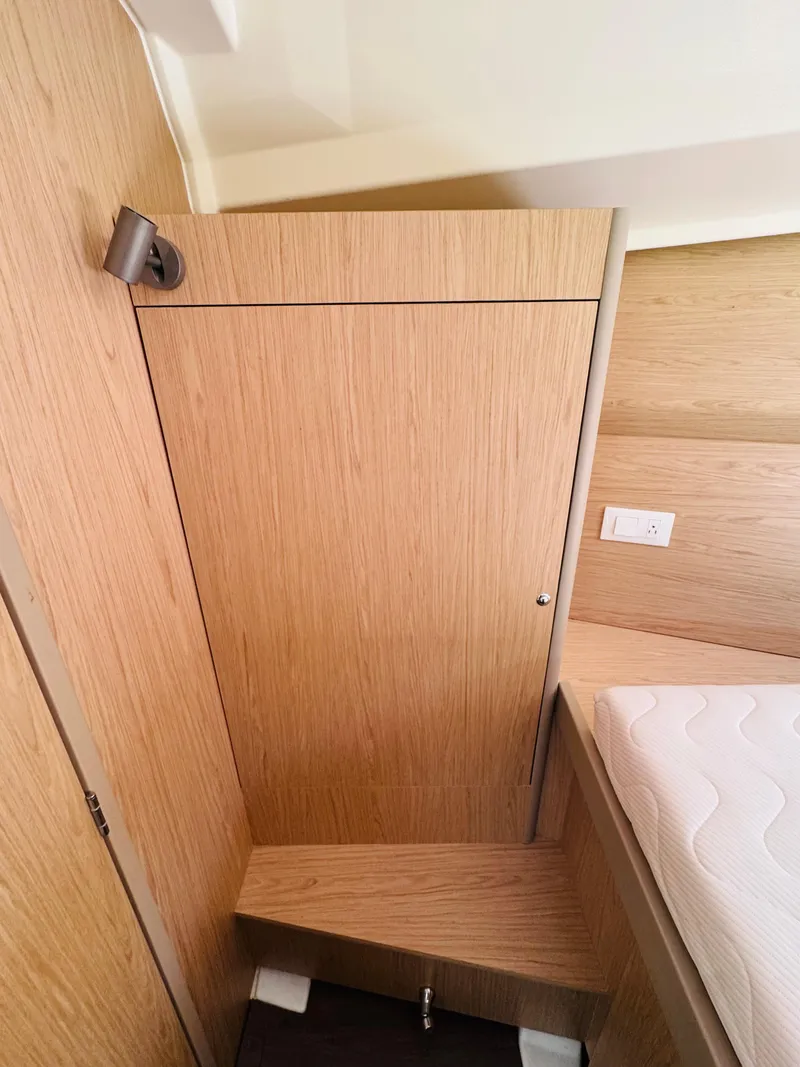 Slide: The Image of Interior cabin of 2020 Beneteau Oceanis 41.1 yacht, featuring wooden paneling and a cozy bed. - 37