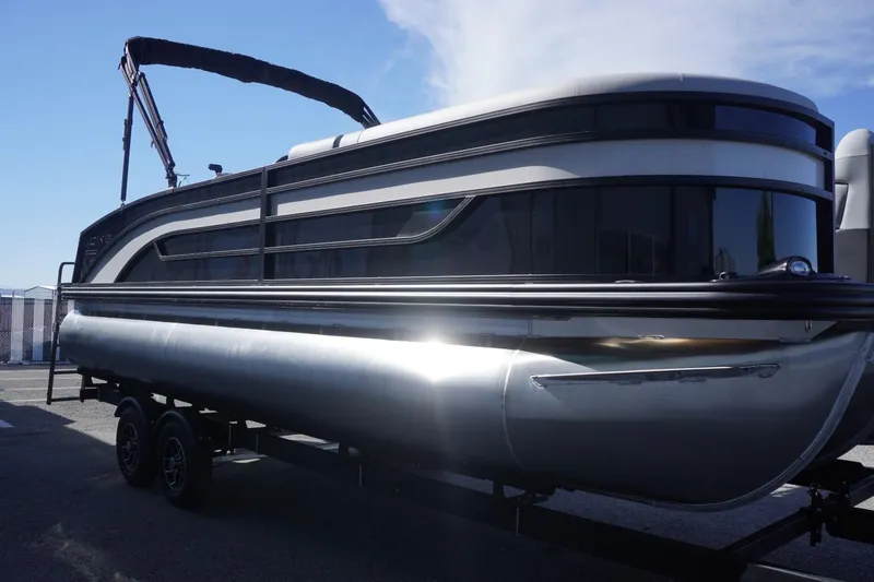Slide: The Image of 2025 Lowe SS 230 DL pontoon boat on trailer, sleek design, sunny day. - 13