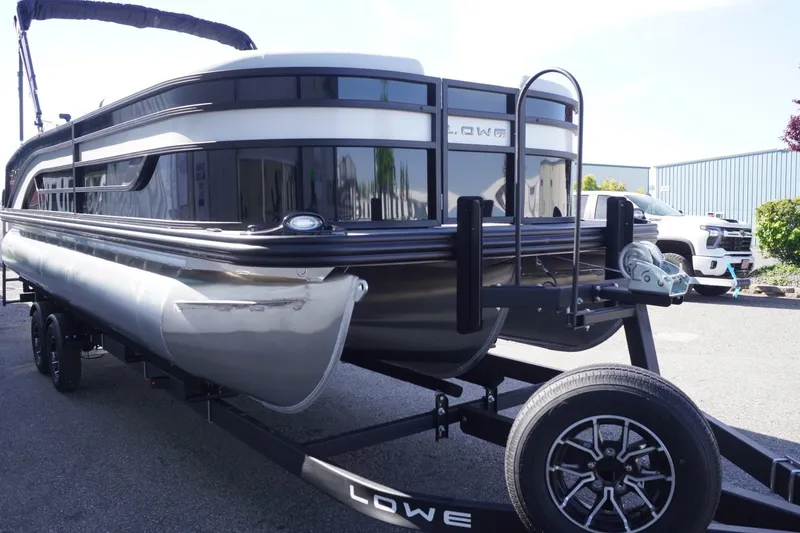 Slide: The Image of 2025 Lowe SS 230 DL pontoon boat on trailer, sleek design, black and silver finish. - 15