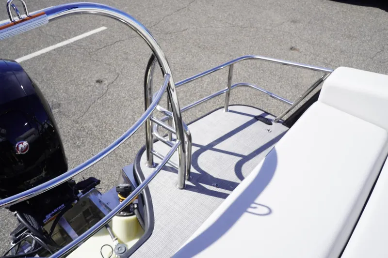 Slide: The Image of 2025 Lowe SS 230 DL pontoon boat with sleek railing and outboard motor. - 20
