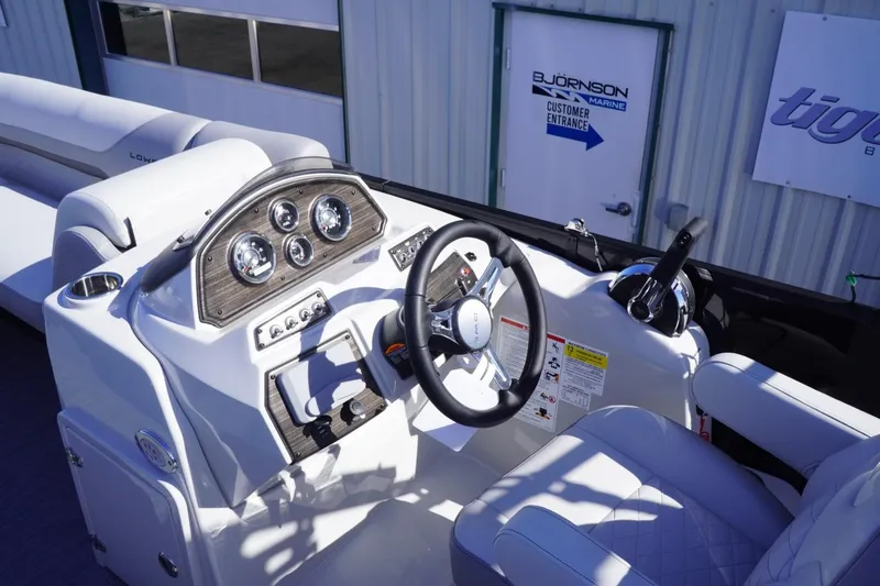 Slide: The Image of 2025 Lowe SS 230 DL boat dashboard with steering wheel and control panel. - 31