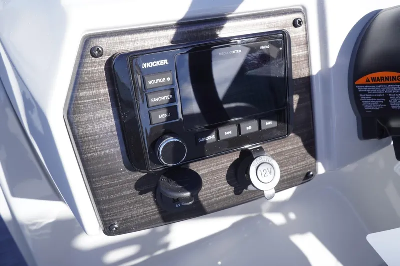 Slide: The Image of 2025 Lowe SS 230 DL boat dashboard with Kicker audio system and 12V outlet. - 32