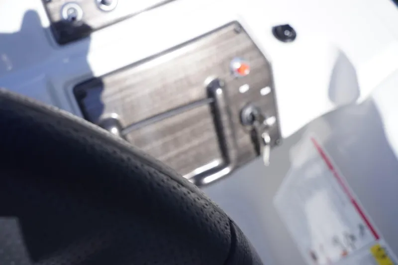 Slide: The Image of Dashboard of a 2025 Lowe SS 230 DL boat with steering wheel and controls. - 35