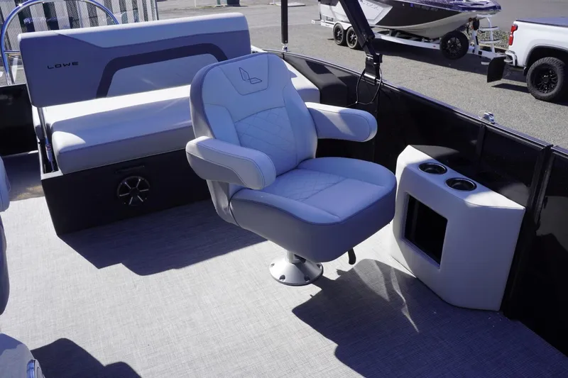 Slide: The Image of 2025 Lowe SS 230 DL boat interior with plush seating and cup holders. - 38
