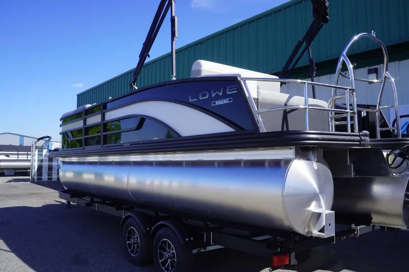 Slide: The Image of 2025 Lowe SS 230 DL pontoon boat on trailer, parked outdoors. - 4