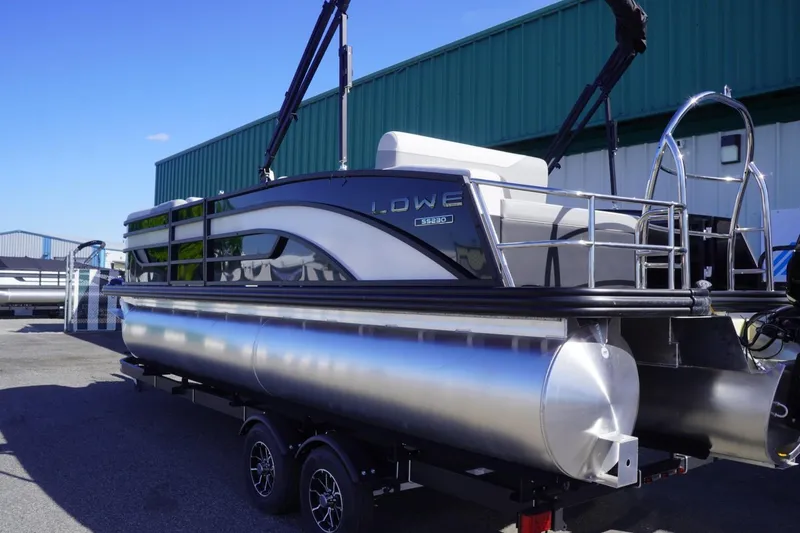Slide: The Image of 2025 Lowe SS 230 DL pontoon boat with sleek design, parked outdoors. - 5