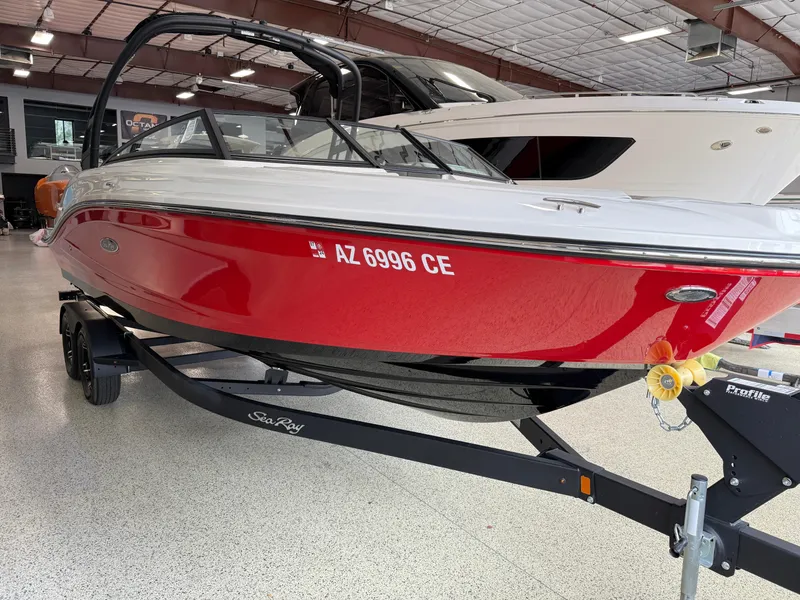 Slide: The Image of 2024 Sea Ray SPX230 boat in showroom, red and white exterior, on trailer. - 10