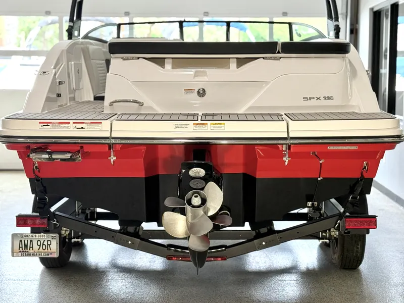 Slide: The Image of 2024 Sea Ray SPX230 boat rear view with red hull and dual propellers. - 8