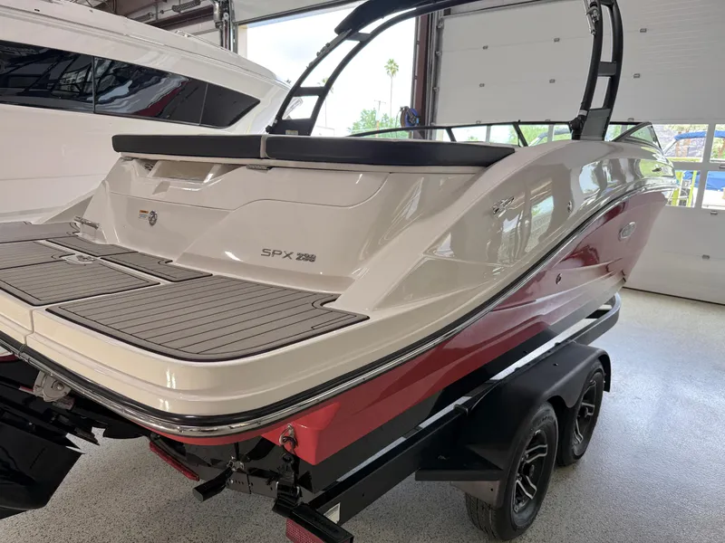 Slide: The Image of 2024 Sea Ray SPX230 boat on trailer in showroom, rear view. - 9