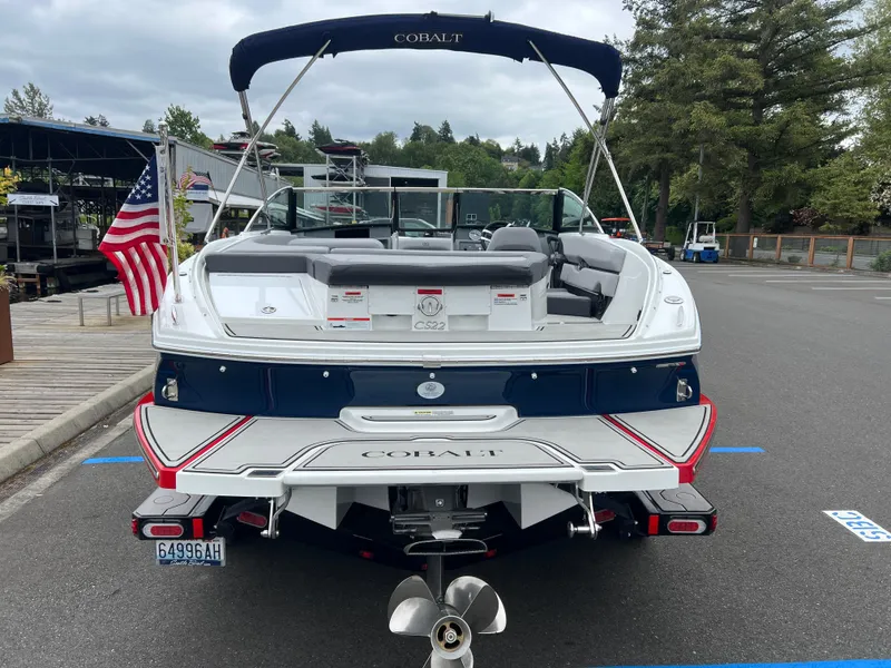 Slide: The Image of 2023 Cobalt CS22 boat with American flag, parked at marina, rear view. - 7