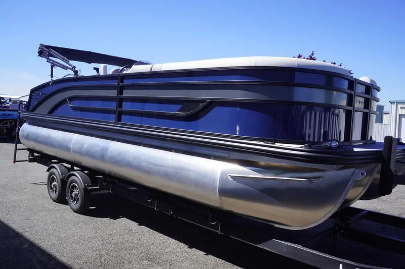 Slide: The Image of 2025 Lowe SS 230 DL pontoon boat on trailer, sleek design, blue and silver finish. - 10