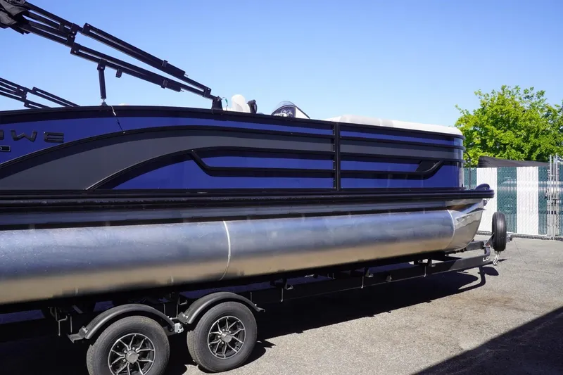 Slide: The Image of 2025 Lowe SS 230 DL pontoon boat on trailer, side view, outdoors. - 11