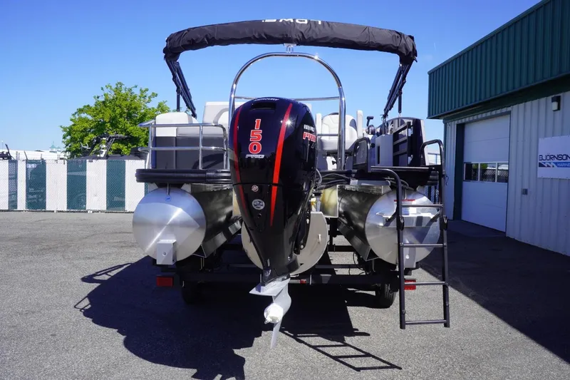 Slide: The Image of 2025 Lowe SS 230 DL pontoon boat with powerful 150 HP engine, parked outdoors. - 14