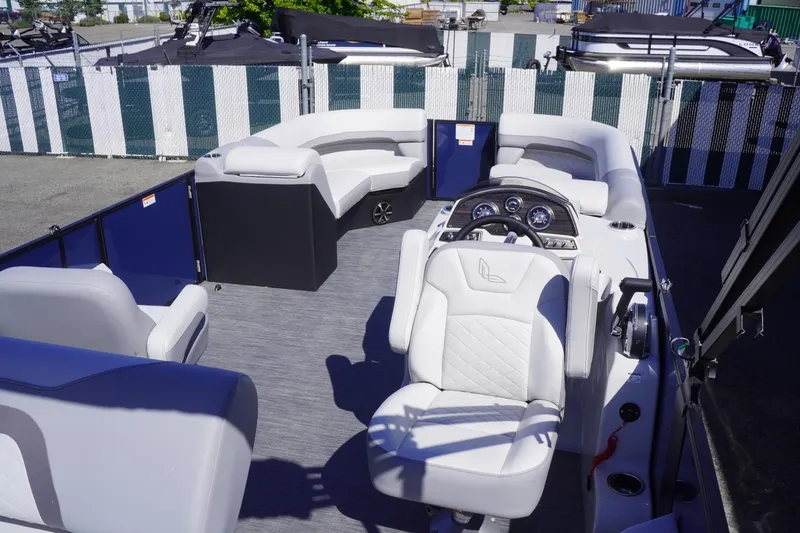 Slide: The Image of 2025 Lowe SS 230 DL pontoon boat interior with plush seating and modern dashboard. - 18