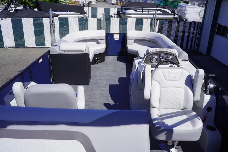 Slide: The Image of 2025 Lowe SS 230 DL pontoon boat interior with plush seating and modern dashboard. - 19
