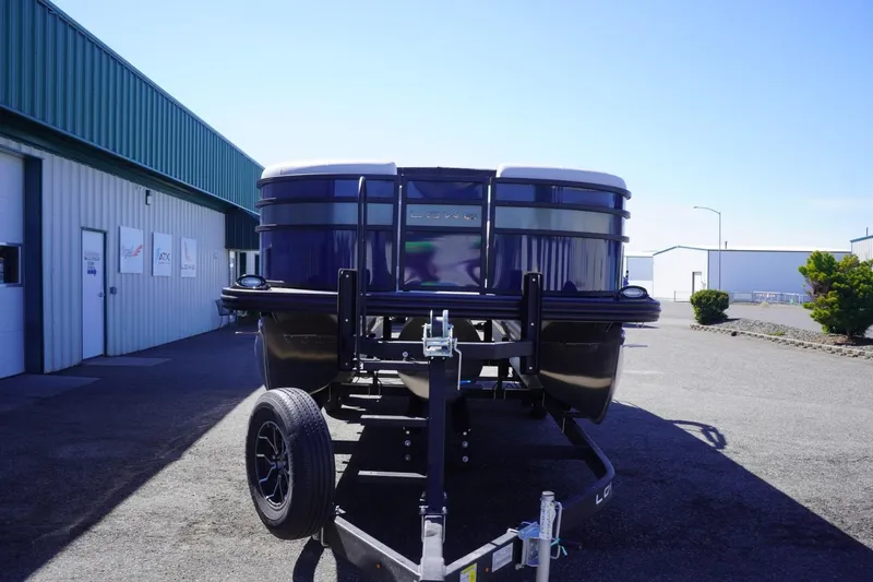 Slide: The Image of 2025 Lowe SS 230 DL pontoon boat on trailer outside industrial building. - 4