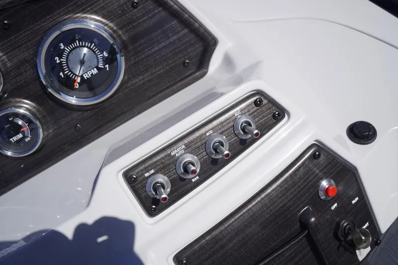 Slide: The Image of Dashboard controls of a 2025 Lowe SS 230 DL boat, featuring RPM gauge and switches. - 44