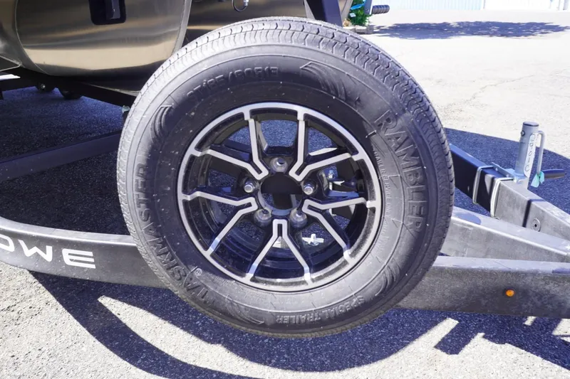 Slide: The Image of Trailer wheel of a 2025 Lowe SS 230 DL boat on pavement. - 6