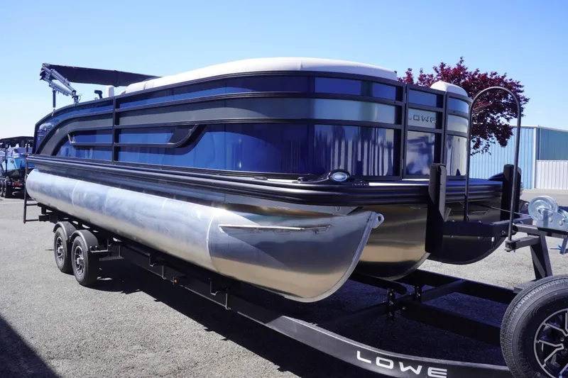 Slide: The Image of 2025 Lowe SS 230 DL pontoon boat on trailer, sleek design, parked outdoors. - 9