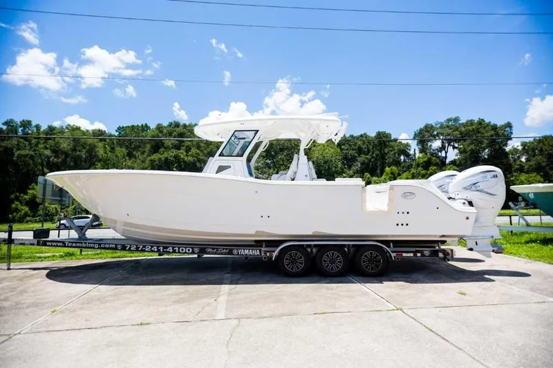 Slide: The Image of 2021 Sea Fox 368 Commander boat on trailer, parked outdoors under a clear blue sky. - 0