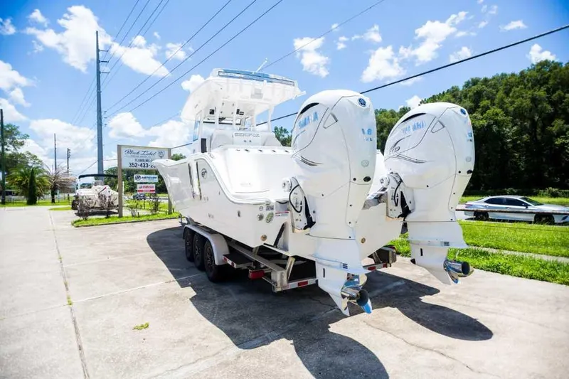 Slide: The Image of 2021 Sea Fox 368 Commander boat on trailer with dual outboard engines, parked outdoors. - 2