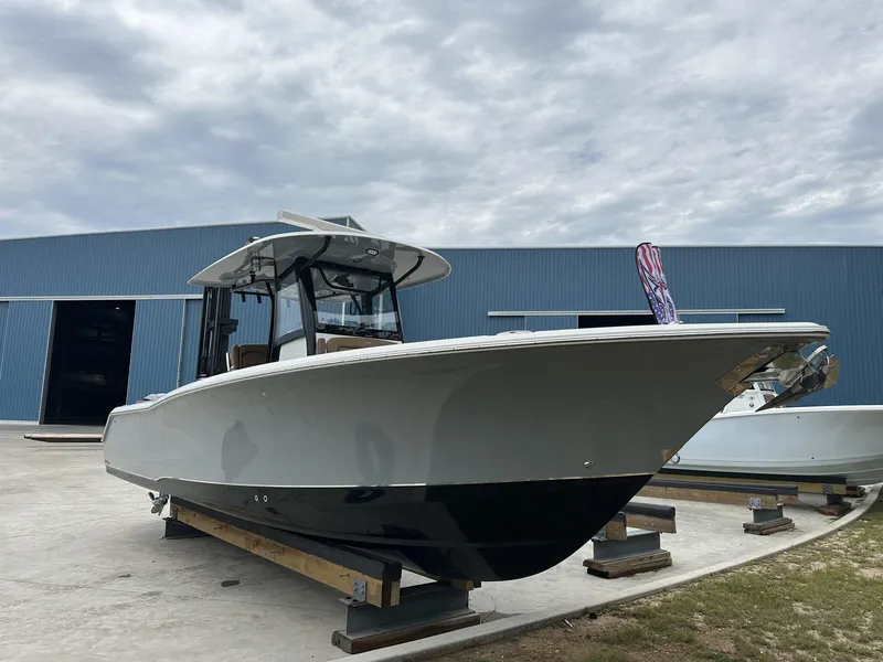 Slide: The Image of 2020 Sea Hunt Gamefish 30 with Coffin Box, docked outdoors near a blue building. - 1