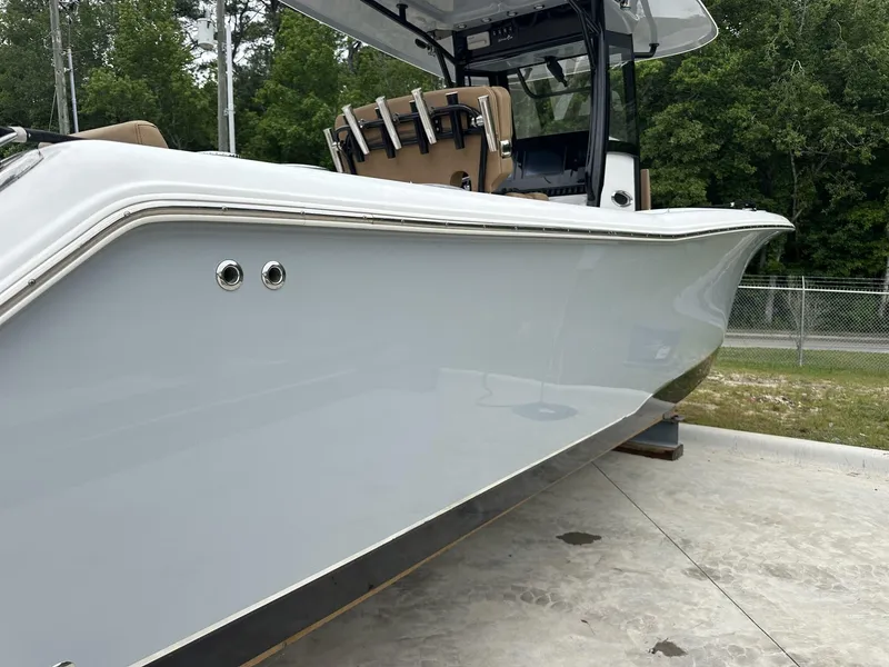 Slide: The Image of 2020 Sea Hunt Gamefish 30 boat with coffin box, sleek design, parked outdoors. - 13