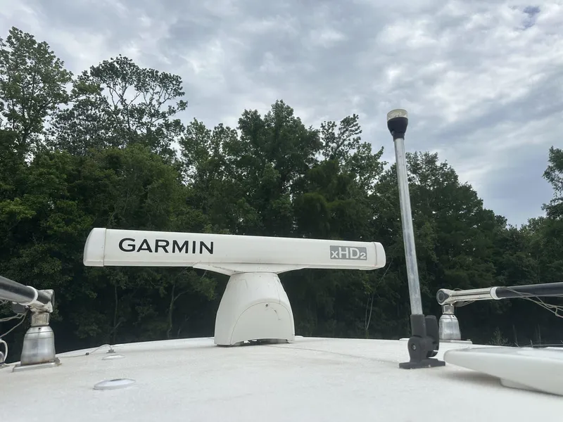 Slide: The Image of Garmin xHD2 radar on 2020 Sea Hunt Gamefish 30 boat, surrounded by trees and cloudy sky. - 32