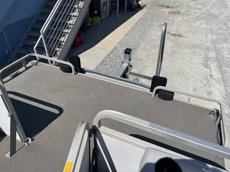 Slide: The Image of 1991 GODFREY MARINE 24 Executive boat deck with metal railings and trailer. - 2